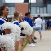 Cheerleaders holding pom poms, standing in a line at the Jamie Hosford Football Center dedication.